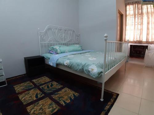 - une chambre avec un lit et un berceau blanc dans l'établissement ORCHIDD HOMESTAY, à Gambang