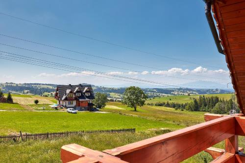 a view of a house on a hill with a fence at Apartament 1010 m in Ząb
