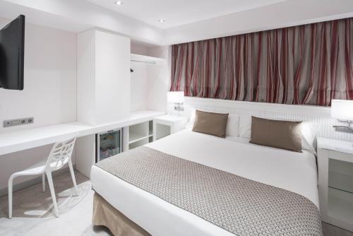 a bedroom with a bed and a desk and a television at Catalonia Roma in Barcelona