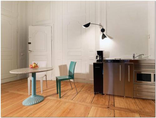 une cuisine avec une table et une chaise verte dans l'établissement Appartement Le 22 - Colmar Centre Parking Privatif en option, à Colmar