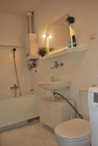 Baño blanco con lavabo y aseo en Pokoje w cichym mieszkaniu 50m od Rynku en Breslavia