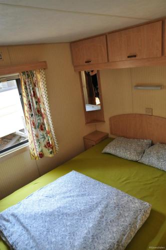 une petite chambre avec un lit et une fenêtre dans l'établissement Greenchalets Lei Suves retro, à Roquebrune-sur Argens