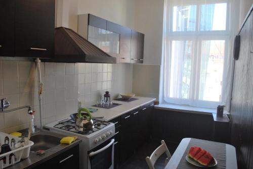 cocina con fogones, fregadero y ventana en Pokoje w cichym mieszkaniu 50m od Rynku en Breslavia