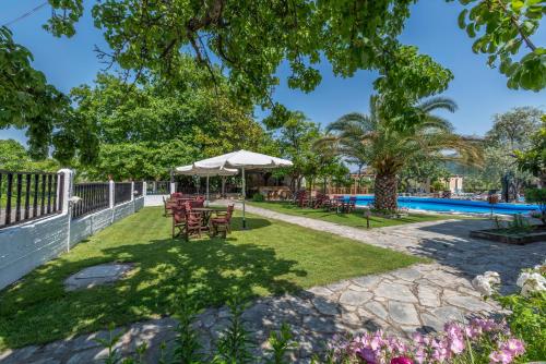 a patio with chairs and umbrellas next to a pool at Natasa Hotel in Skala Potamias