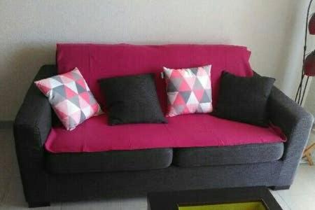 a pink couch with pillows on it in a room at Appartement Narbonne in Narbonne
