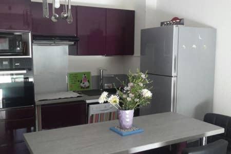 a kitchen with a table with a vase of flowers on it at Appartement Narbonne in Narbonne
