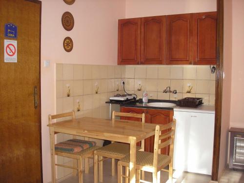 a kitchen with a wooden table and chairs and a counter at Stara Breza 1 Rooms in Palić
