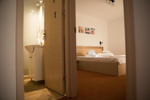 a bedroom with a bed and a door leading into a room at SaloS Beach Resort in Mamaia Nord