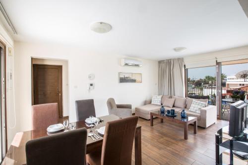a living room with a couch and a dining room at Napiana Apartments in Ayia Napa