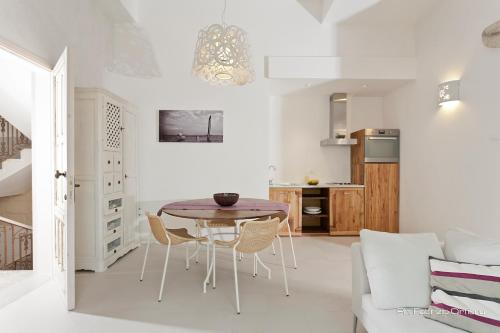 Il comprend une cuisine et un salon avec une table et des chaises. dans l'établissement Palazzo Dei Dondoli, à Lecce