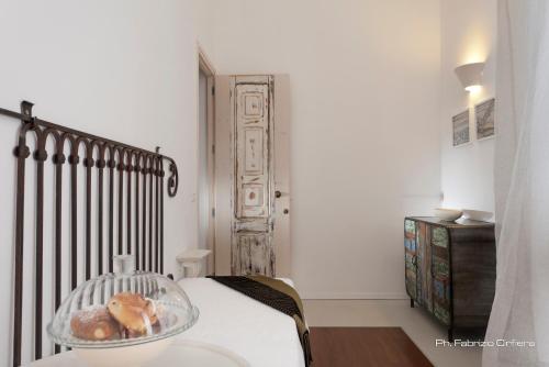 a bedroom with a bed with a glass bowl with donuts on it at Palazzo Dei Dondoli in Lecce