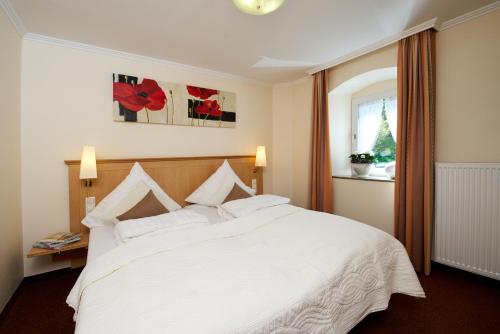 a bedroom with a white bed and a window at Landhotel Krolik in Daun