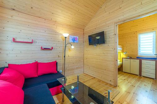 un soggiorno con divano rosso in una camera in legno di Pod Gruszą Wicie a Wicie