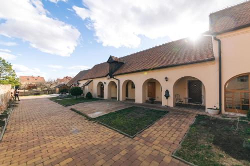 a large white building with a brick courtyard at Dům Přátel Pavlova in Pavlov