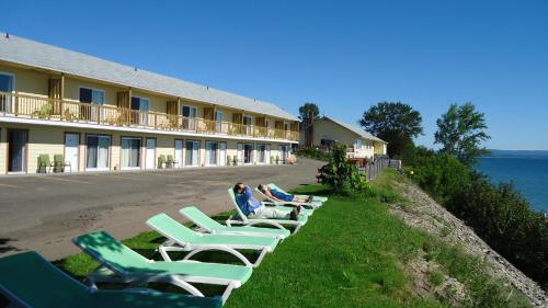 a row of lounge chairs in front of a hotel at Motel Carleton Sur Mer in Carleton sur Mer