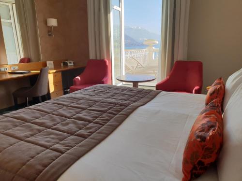 a hotel room with a bed with a large window at Impérial Palace in Annecy