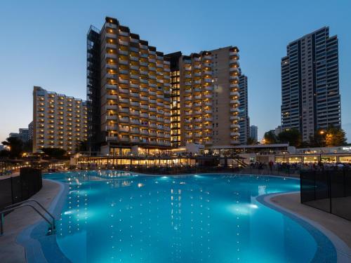 une grande piscine en face de deux grands bâtiments dans l'établissement Medplaya Hotel Rio Park, à Benidorm
