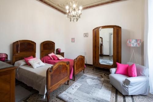 a bedroom with two beds and a mirror and a chair at Corso Mazzini in Savona
