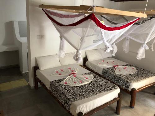 En eller flere senge i et værelse på Pemba Paradise