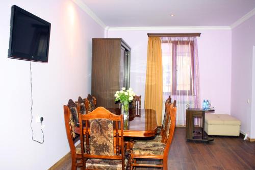 a dining room with a table and chairs and a television at Christy Hotel in Goris