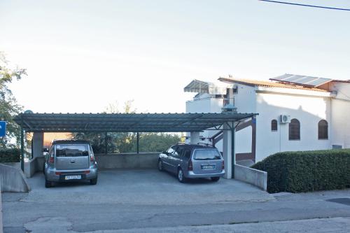 two cars parked in a parking lot next to a building at Apartments Matic in Njivice