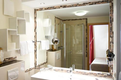 a bathroom mirror with a sink and a shower at Landhotel Krolik in Daun