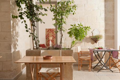a patio with two tables and potted plants at Palazzo Dei Dondoli in Lecce