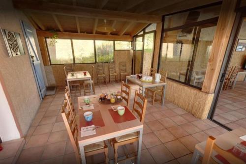 een kamer met tafels en stoelen in een huis bij Mas du Colombier in Saint-André-les-Alpes