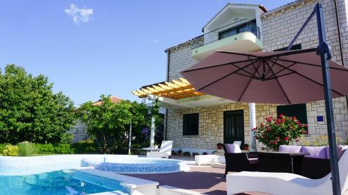 馬里斯通的住宿－斯蓋別墅，一个带遮阳伞和游泳池的庭院