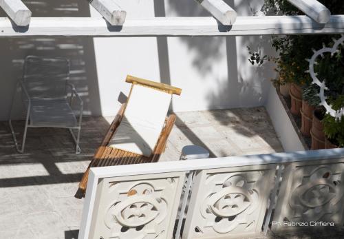 a wooden chair sitting on a porch next to a ladder at Palazzo Dei Dondoli in Lecce