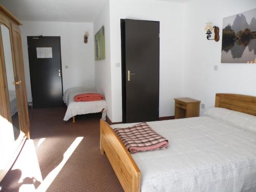 - une chambre avec 2 lits et une table dans l'établissement Mas du Colombier, à Saint-André-les-Alpes
