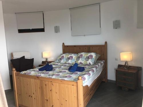 カレタ・デ・ファマラにあるCasa Susanneのベッドルーム1室(木製ベッド1台、ランプ2つ付)