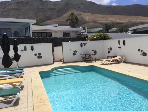 a swimming pool in front of a villa at Casa Susanne in Famara