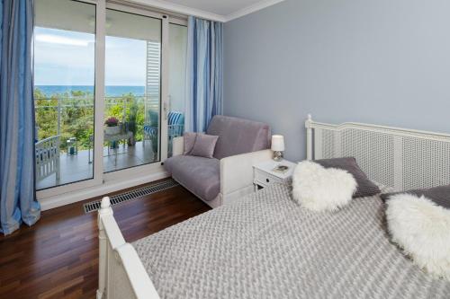 sypialnia z łóżkiem i kanapą oraz balkonem w obiekcie Apartament Playa Baltis 66 z widokiem na morze w mieście Międzyzdroje