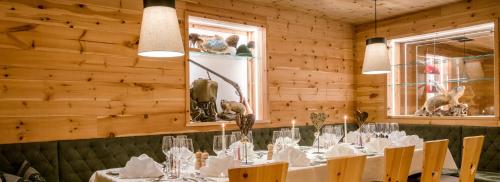 a dining room with a table with white table cloth at Tratterhof Mountain Sky Hotel in Maranza