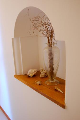 a vase on a wooden shelf with a plant in it at Villa Yiara in Positano