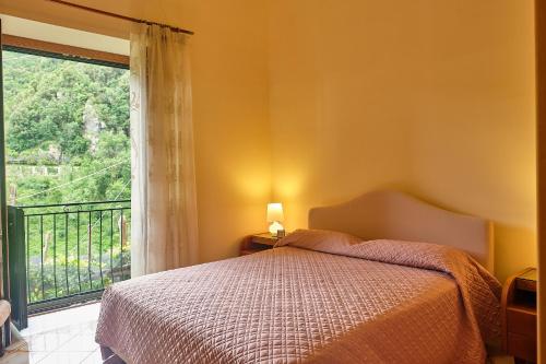 una camera con un letto e una grande finestra di Villa Pricitella ad Amalfi