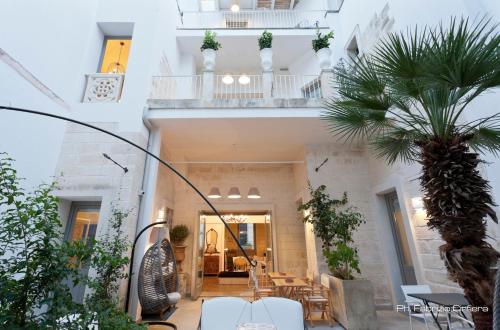 a house with a palm tree in a courtyard at Palazzo Dei Dondoli in Lecce