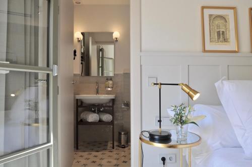 a bedroom with a bed and a sink and a table with a lamp at Hotel Basilica in Palma de Mallorca