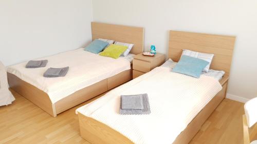 two twin beds in a room with wooden floors at Apartament Miarki 3 in Świnoujście