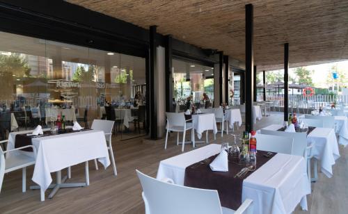 un restaurante con mesas blancas y sillas blancas en Medplaya Hotel Rio Park, en Benidorm