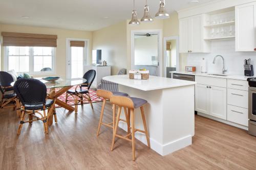 a kitchen with white cabinets and a table and chairs at The Hotel Maria in Westerly