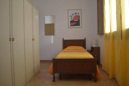 a small bedroom with a bed with a yellow blanket at Sinis my love in Càbras