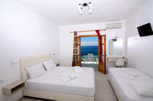 sypialnia z 2 łóżkami i widokiem na ocean w obiekcie Mare Blu w mieście Parga