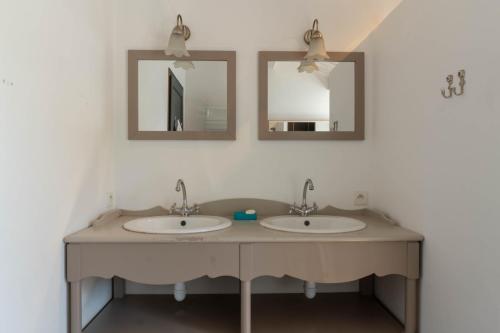 deux lavabos dans une salle de bain avec deux miroirs dans l'établissement Sea-Snow Guest Houses, à Talmont-Saint-Hilaire