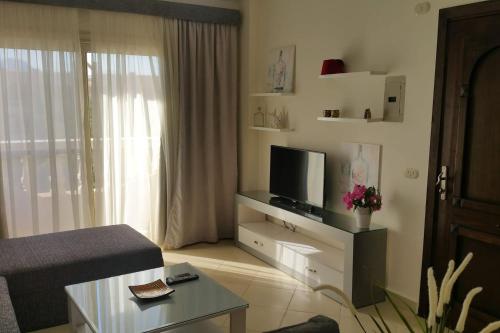 a living room with a tv and a couch at One- bedroom apartment S3 in Vip Zone Sunny Lakes in Sharm El Sheikh