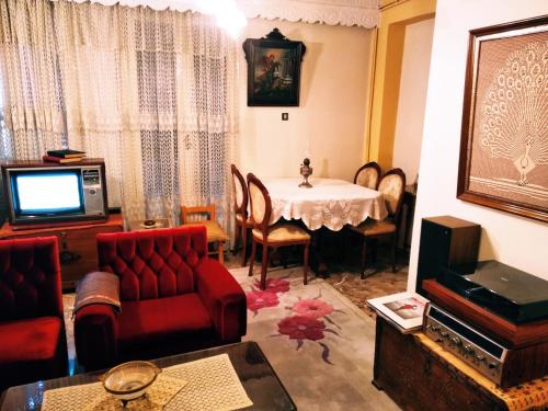 a living room with a table and a tv at Xista Manor House ® in Pyrgi