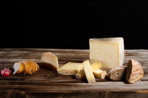 a bunch of cheese and bread on a wooden table at Hotel I Rododendri in Valfurva