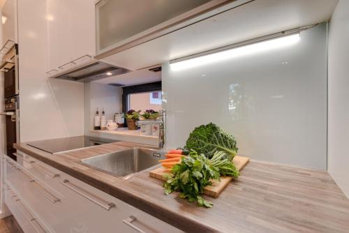 a kitchen with a sink and vegetables on a counter at Apartment Oliveto Sibenik in Šibenik