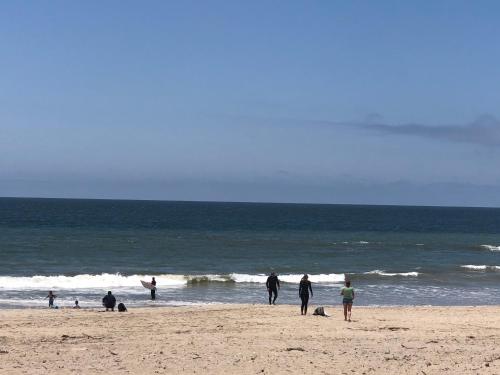 a group of people walking on the beach at The Shores Inn in Ventura